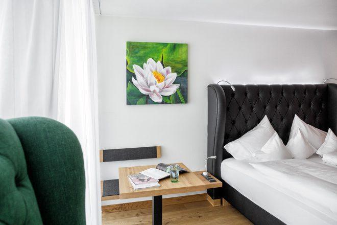 Detailaufnahme eines Schlafbereichs mit einem großen Doppelbett aus schwarzem Leder