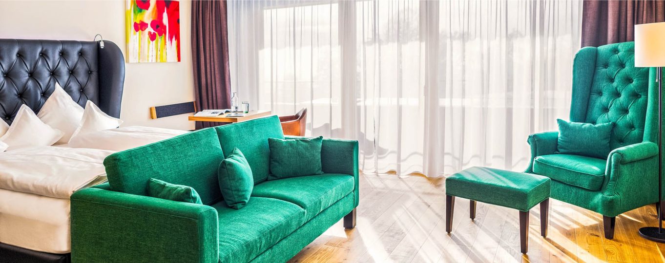 Einblick in einen Wohnbereich mit grünen gemütlichen Sitzmöglichkeiten