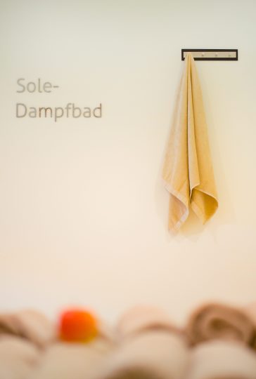 Ein Handtuch hängt an der Wand neben der Beschriftung "Sole-Dampfbad" in einem Wellnesshotel in Bregenz