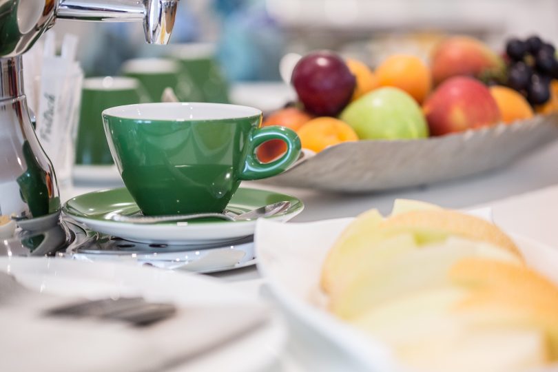 Detailaufnahme einer Tasse die zwischen dem Frühstücksbuffet steht