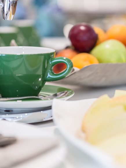 Detailaufnahme einer Tasse die zwischen dem Frühstücksbuffet steht