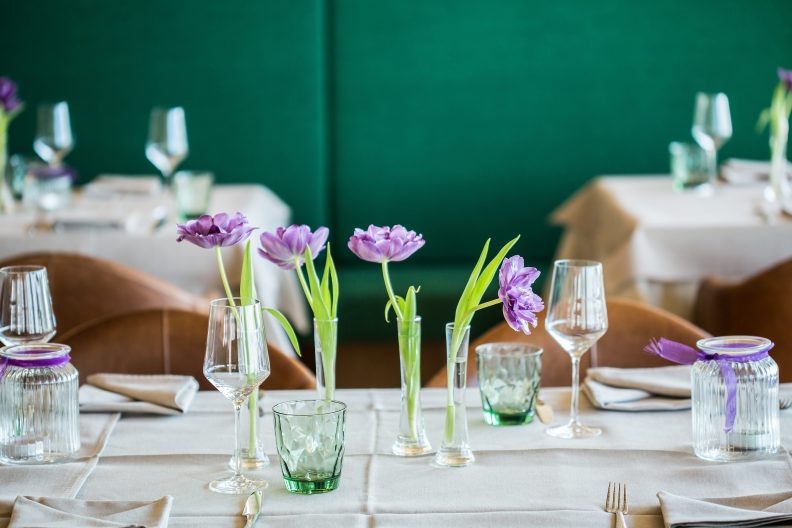 Detailaufnahme von gedeckten Tischen mit lila Blumen