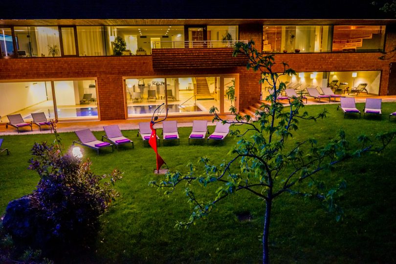 Beleuchteter Garten eines Wellnesshotels am Bodensee mit Seeblick bei Nacht mit Liegestühlen
